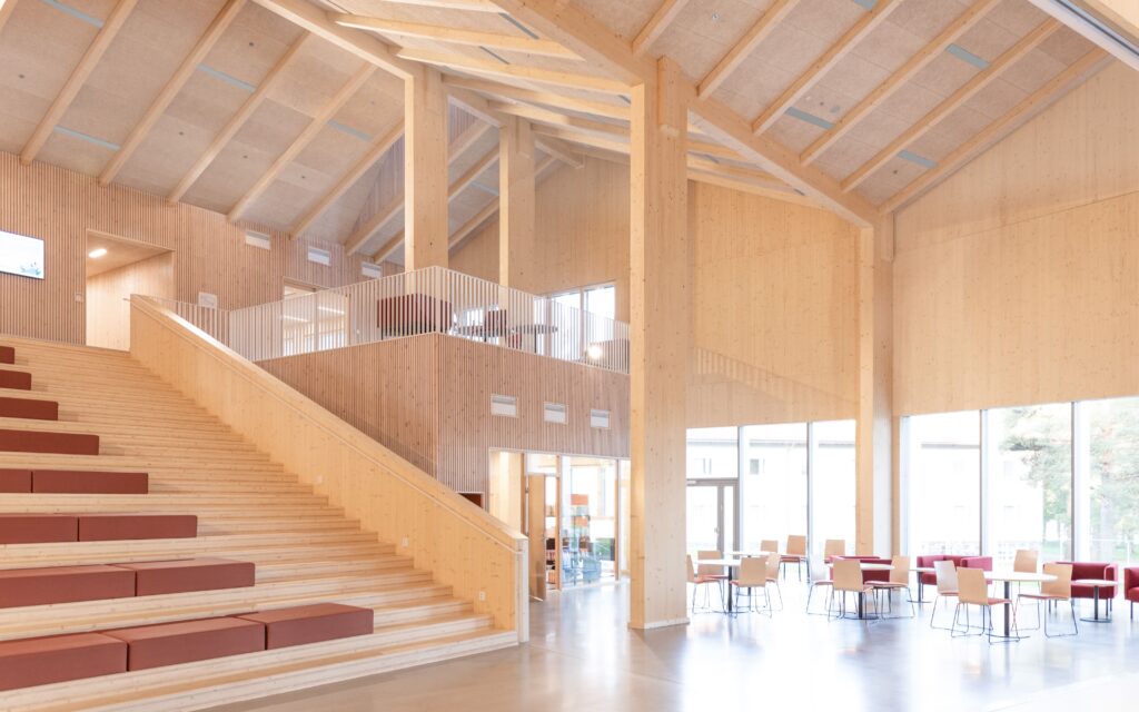A wide wooden stair in the central lobby of Lastu forms a gathering space in the heart of the new education building