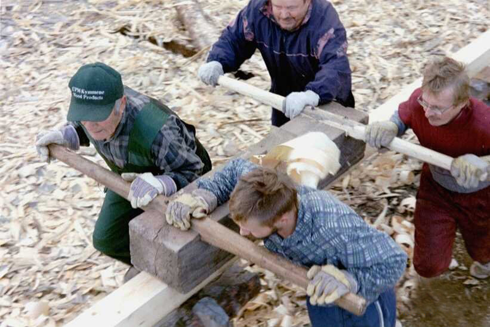 Four men working on surfacing the logs for the Kärsämäki Shingle Church