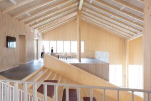 Interior view of the Lastu education building showing the wide wooden stairs and the lobby on the second floor