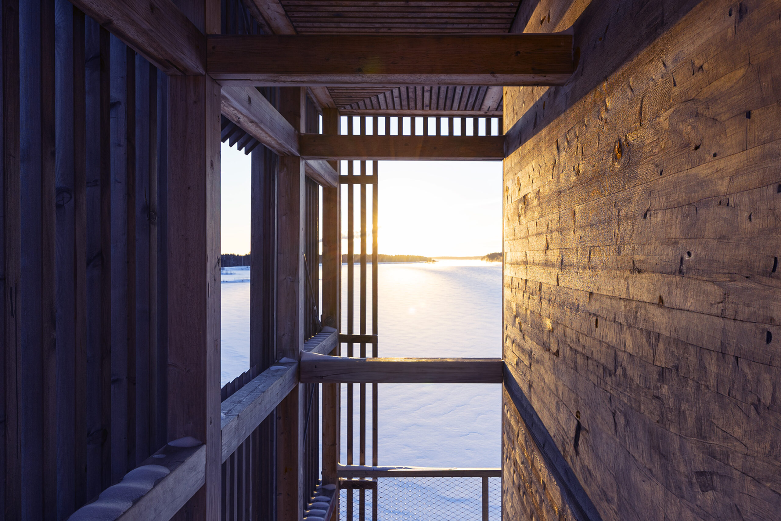 Looking out from the wooden viewing tower, Periscope over the lake with afternoon sun glimmering on the snowy landscape
