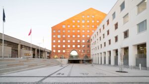 Seinäjoki Station Square, showing the red brick building with the main entrance to the station in the background in the middle and the white wellbeing service center on the right. Photo by Hannu Rytky
