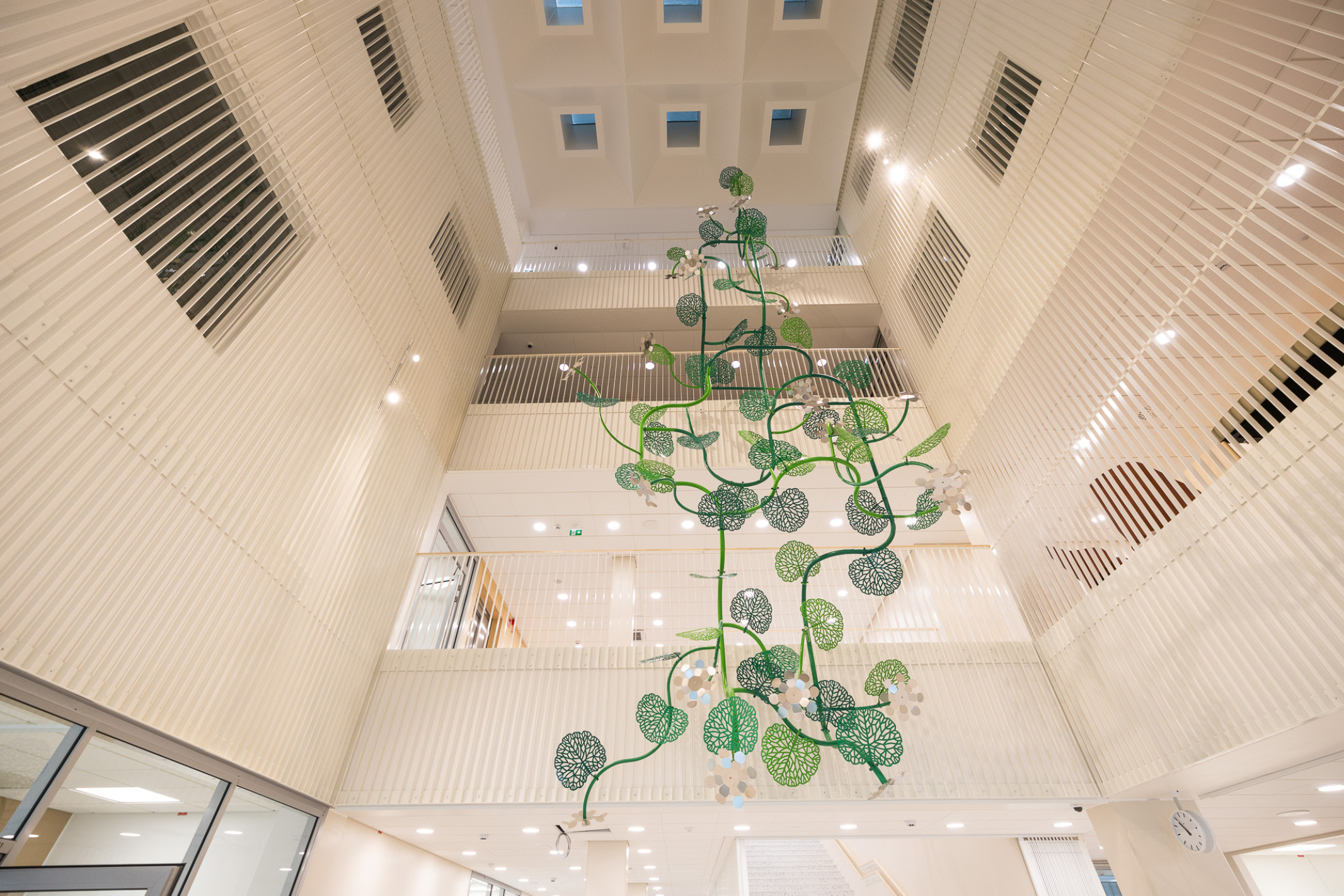 The open central lobby with a sculptural art piece in the middle. Photo by Anssi Lassila