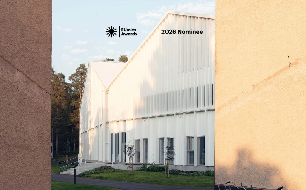 A photograph with the stamp for buildings that have been nominated for the EU Mies Awards. Showing how the new white wooden education building, Lastu takes its place in the context of the existing buildings on the campus.
