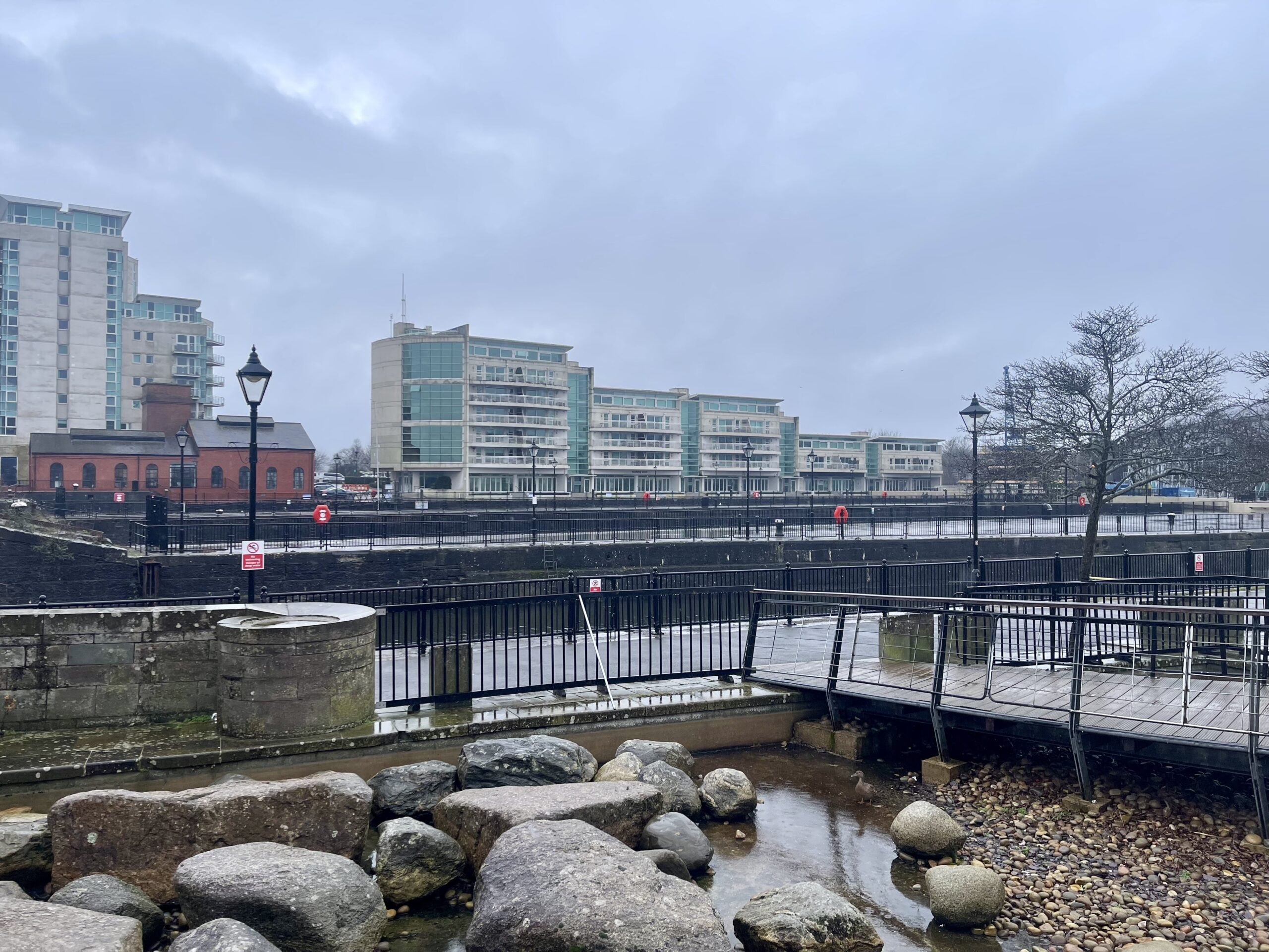 View of the Cardiff Bay with. a stone garden in the front and residential buildings in the background