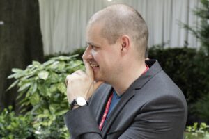 Portrait of a person in gray suit with greenery in the background